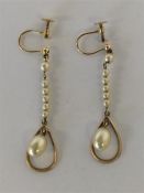 A pair of stylish gold drop earrings with loop top