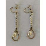 A pair of stylish gold drop earrings with loop top