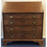 A Georgian oak four drawer hinged top bureau with