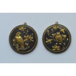 A pair of unusual Shakudo pendants depicting wild