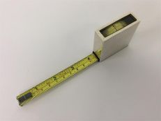 A novelty engine turned tape measure with glass in