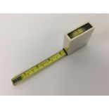 A novelty engine turned tape measure with glass in