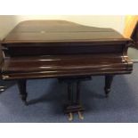 A rosewood grand piano on fluted supports with bra