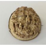 A small carved brooch of an Oriental scene in gold