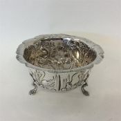 A small chased sugar bowl decorated with flowers a