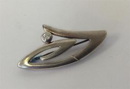 A diamond single stone mounted as a brooch of styl