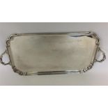 A small two handled tray with cut corners and scro