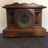 A small oak mantle clock with brass dial. Est. £20