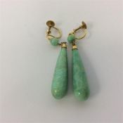 A pair of gold teardrop earrings with ball tops. A