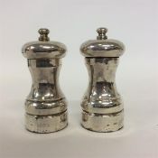 A pair of good modern pepper grinders with twisted