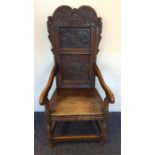 A heavy oak carved hall chair with stretcher base