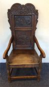 A heavy oak carved hall chair with stretcher base