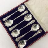 A boxed set of six soup spoons attractively decora