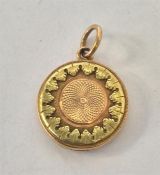 A small circular three colour gold locket with loo