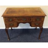 A walnut five drawer lowboy with moulded frieze an
