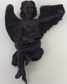 An unusual carved figure of a winged infant. Est.