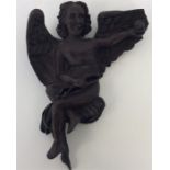 An unusual carved figure of a winged infant. Est.