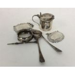 A collection of napkin rings, teaspoons, wine labe