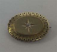 An oval 15 carat target brooch with central diamon