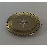 An oval 15 carat target brooch with central diamon