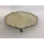 A pie-crust salver with wavy edge on four scroll f