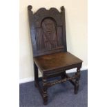 An oak hall chair with warrior decoration and turn