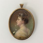 An oval signed miniature of a lady with pearl neck