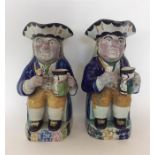 A pair of decorative Toby jugs on square bases of