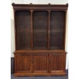 A large oak Gothic style two part bookcase on brac