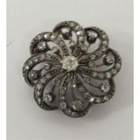 A diamond circular swirl brooch in claw mount. App