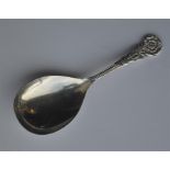 A silver caddy spoon with rose decoration. Birming