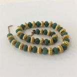 A good string of gold and green stone uniform bead