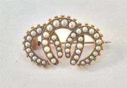 An oval 15 carat triple horseshoe and pearl brooch