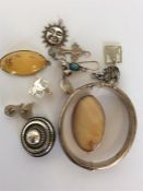 A bag containing silver bangle, pendants, brooches