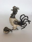An unusual clock in the form of a rooster in stand