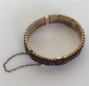 A garnet hinged bangle with concealed clasp and sa