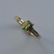 A peridot and diamond nine stone ring in gold. App