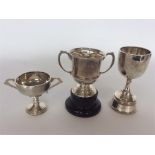 Three silver trophy cups with engraved decoration.