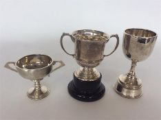 Three silver trophy cups with engraved decoration.