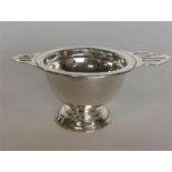 A stylish tea strainer on stand on pedestal base.