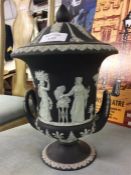 A black Wedgwood urn shaped jardiniere and cover.