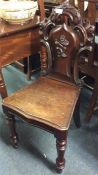 A mahogany hall chair with scroll decoration.