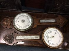 Two oak carved barometers with white enamel dials.