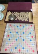 An old scrabble game together with a silver bowl.