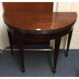 A mahogany D-ended card table.