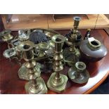 A large collection of brass candlesticks and other