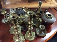 A large collection of brass candlesticks and other