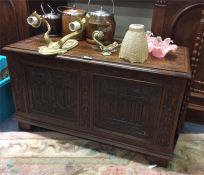 An oak carved front panelled blanket box.