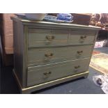 A green and gold painted chest of drawers.