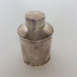 A silver tea caddy with sloping top and lift-off c